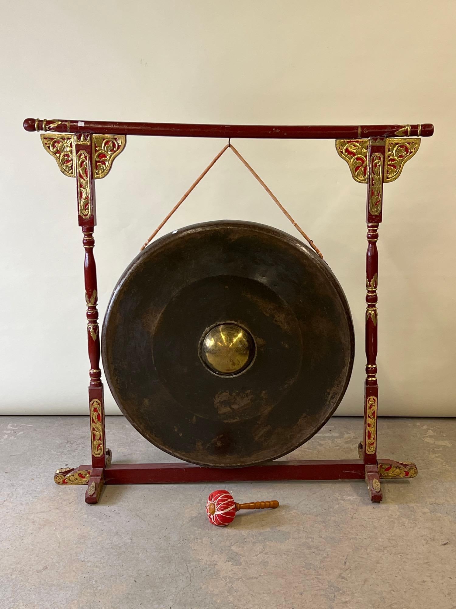 Indonesian Gamelan Gong on Stand: An Indonesian Gamelan gong hanging on a carved and painted wood stand. With mallet. 54in tall x 54in wide. Gong by itself: 36in diameter x 10-1/2in deep. | Philadelphia Metro area delivery, NYC curbsi