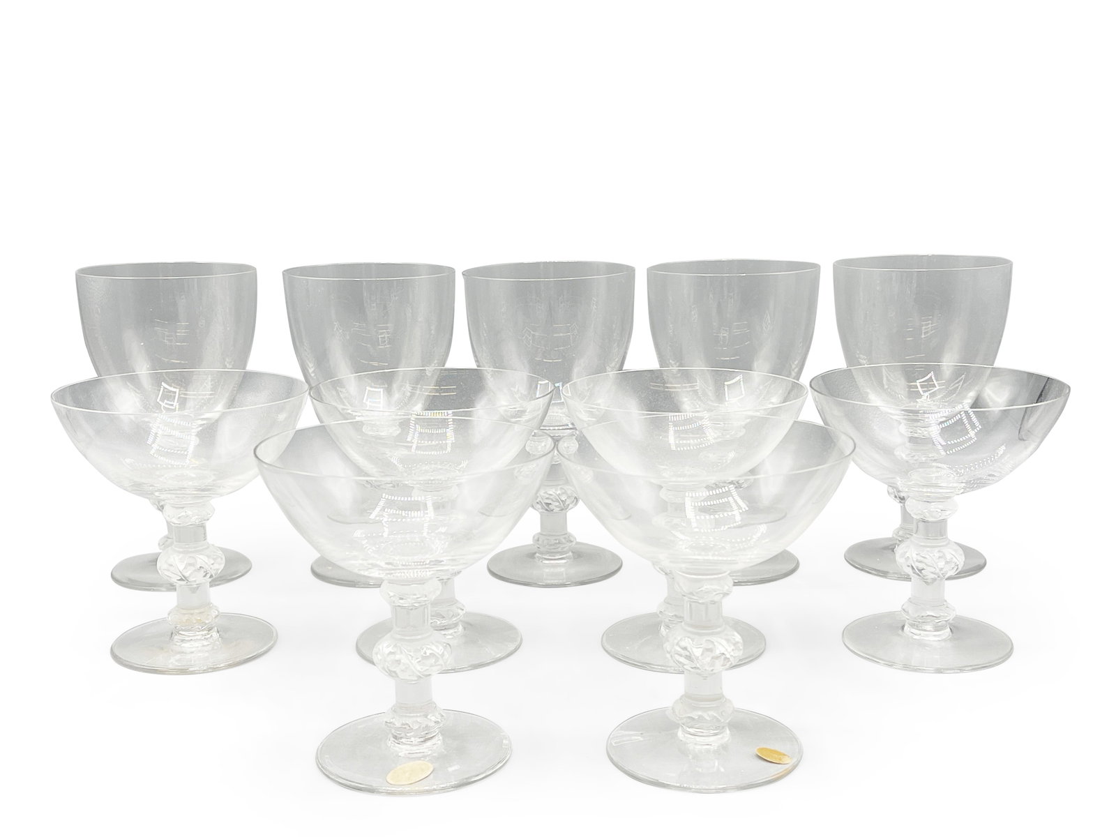 11 Lalique Crystal Coupe and Wine Glasses: A grouping of 11 early Lalique crystal glasses to include five wine glasses and six coupe glasses, each with cut-crystal bases. Each signed Lalique on base. Wines: 6-1/2in tall x 3-1/2in wide. Coupes: