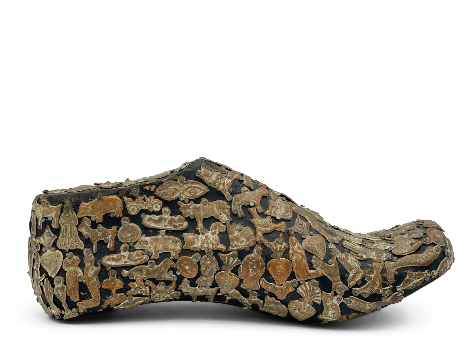 Milagros Folk Art Charm-Adorned Shoe: A Mexican Milagros folk art wooden shoe adorned with mixed-metal charms to include religious figures. 4in tall x 9in wide. | Philadelphia Metro area delivery, NYC curbside delivery, and international 
