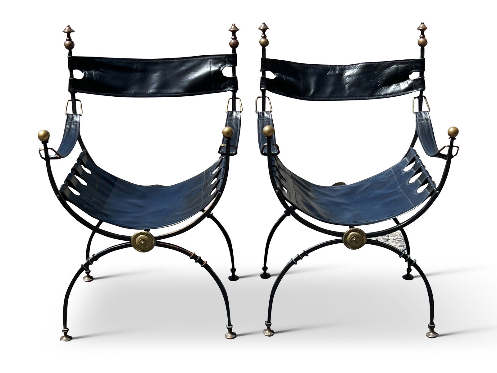 Pair of Wrought Iron and Brass Curule Chairs: A pair of Continental wrought iron and brass curule or Savonarola chairs with brass accents and leather sling seats and backs. 33in tall x 21in wide x 16in deep. | Philadelphia Metro area delivery, NY
