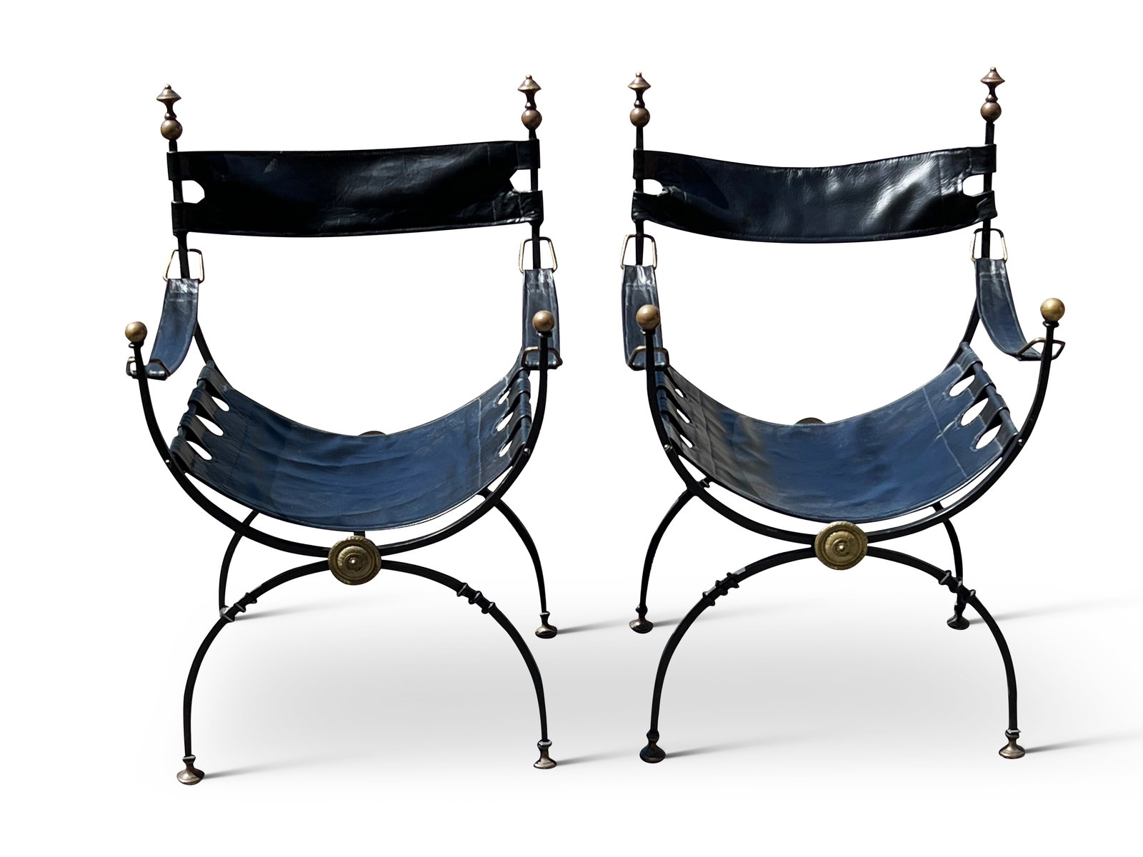 Pair of Wrought Iron and Brass Curule Chairs: A pair of Continental wrought iron and brass curule or Savonarola chairs with brass accents and leather sling seats and backs. 33in tall x 21in wide x 16in deep. | Philadelphia Metro area delivery, NY