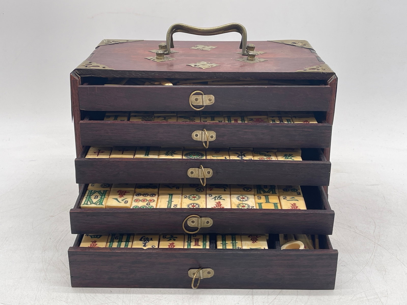 Chinese Traveling Mah Jong Set: A Chinese traveling Mah Jong set with five drawers filled with tiles. Box has handle and brass details. 7in tall x 9-1/2in wide. | Philadelphia Metro area delivery, NYC curbside delivery, and internat