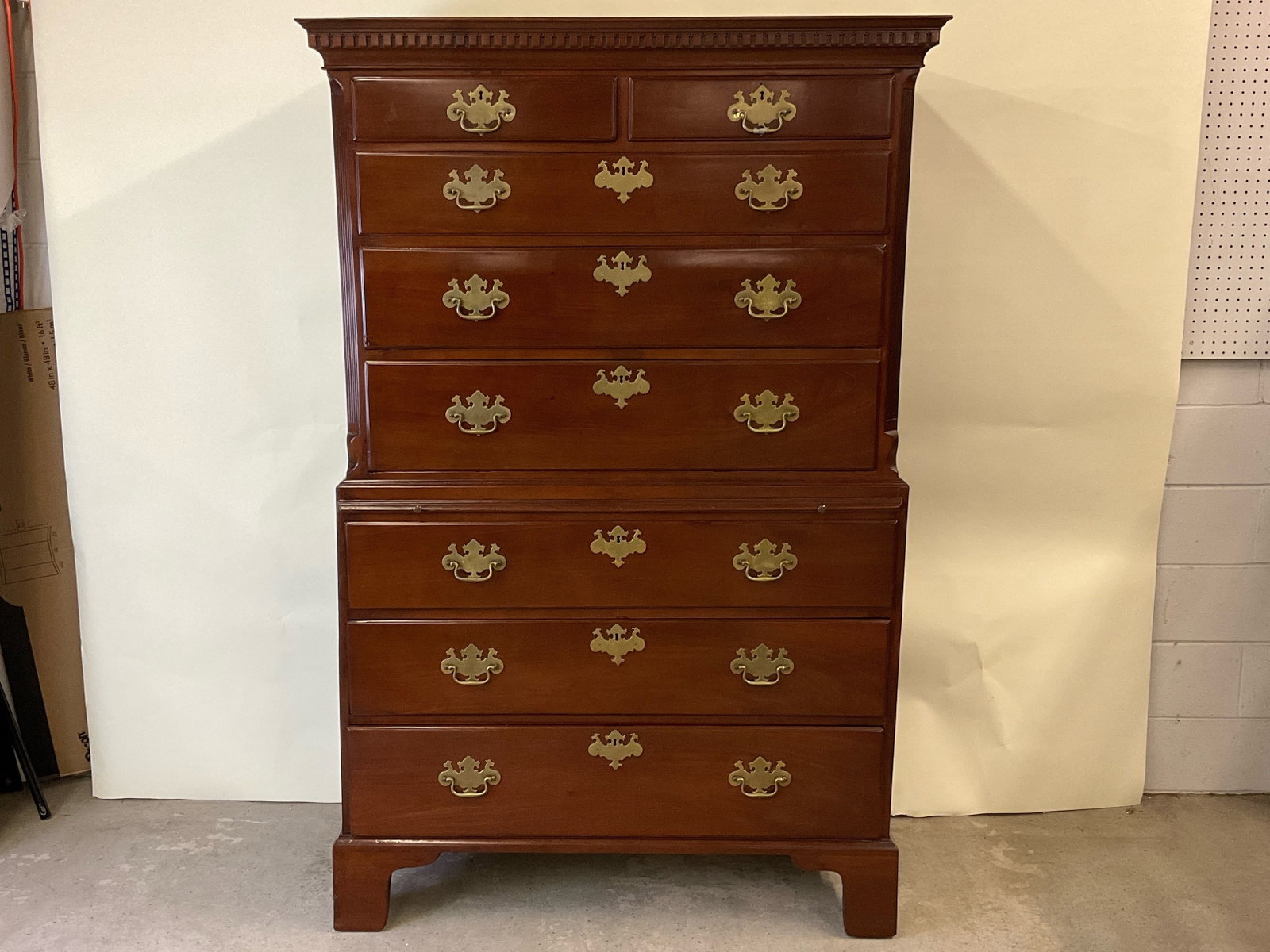 Chippendale Chest-On-Chest: A two-piece Chippendale chest-on-chest, the upper piece having a flat molded top above two short drawers over three long drawers, flanked by reeded sides; and the lower piece with three long drawers, 