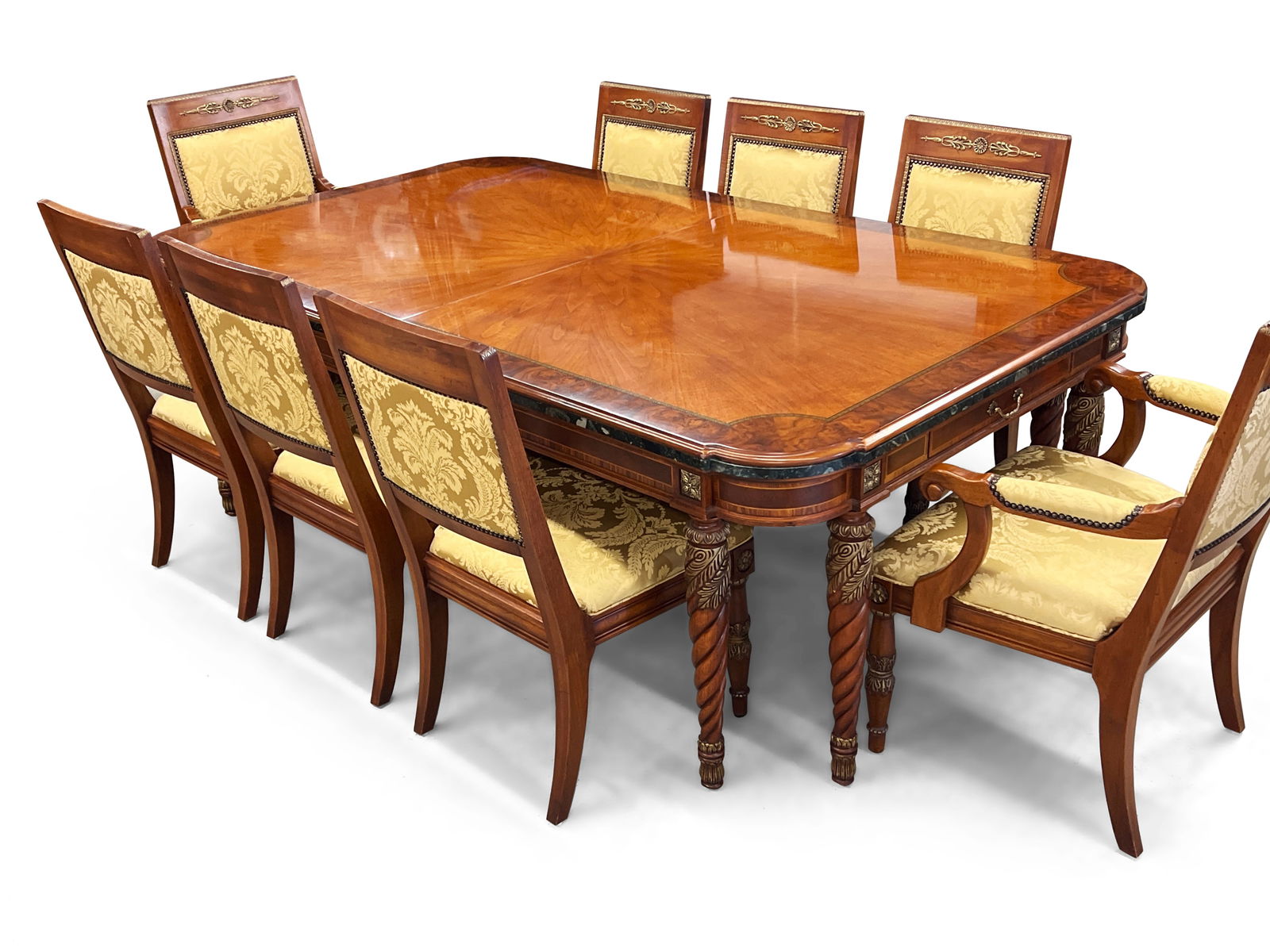 Henredon Empire-Style Dining Table and Chairs: A Henredon French Empire-style extension dining table with a banded and inlaid top with marble trim, drawers on either end, and raised on eight spiral turned legs. With two leaves and eight matching c