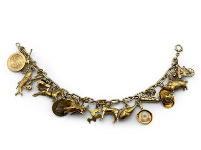 14K Yellow Gold Charm Bracelet: A 14K yellow gold charm bracelet with 18 charms. All charms are either marked or test as 14K. Clasp is also marked 14K. 6in long. 19.5 dwt total. | You have additional shipping options! Philadelphia M