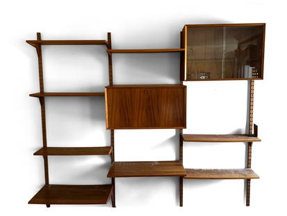 Poul Cadovius Teak Wall Unit for Cado: A Poul Cadovius Danish teak wall unit for Cado, comprised of four uprights, a glass-front sliding china cabinet, a fall-front bar cabinet, and eight open shelves. 80in tall x 95in wide. | You have add