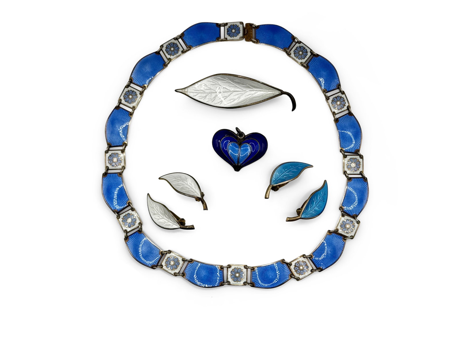 Grouping of David Andersen Enameled Jewelry: A grouping of David Andersen enameled jewelry to include a link necklace, two pairs of leaf-form clip-on earrings, a heart-shaped pendant, and a leaf-form pin brooch. All signed. Necklace: approx. 15i