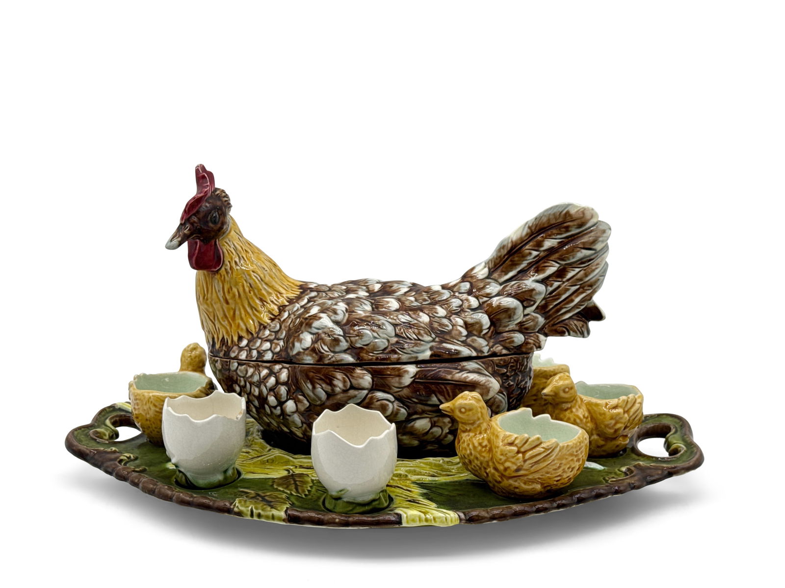 Julius Dressler Majolica Hen Tureen & Egg Cups: A Julius Dressler majolica hen tureen with two egg cups, five chick bowls, and a serving platter. Signed "Austria 2910" under hen. Tray is impressed with Julius Dressler mark. Tureen: 6in tall x 9in w