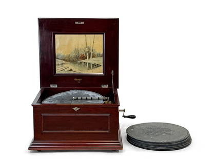 Olympia Double-Comb Music Box: An Olympia double-comb disc music box with a raised panel case and landscape scene under lid. Patent date of 1902. Includes 27 discs. Box: 14in tall x 22in wide x 20in deep. | You have additional ship