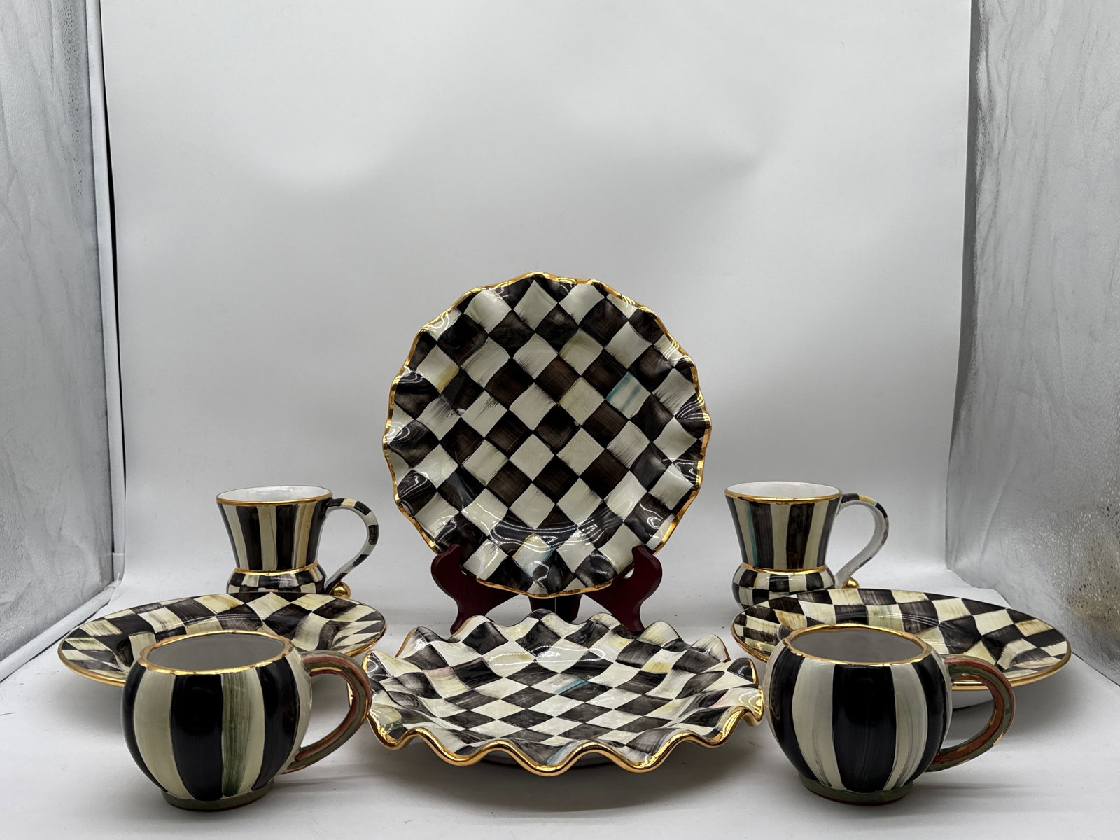 Eight-Piece MacKenzie-Childs Courtly Check Grouping: A MacKenzie-Childs Courtly Check ceramic grouping to include two ruffled plates, two cocoa mugs, two tea cups, and two bowls. Largest: 11 in diameter. | You have additional shipping options, and are n