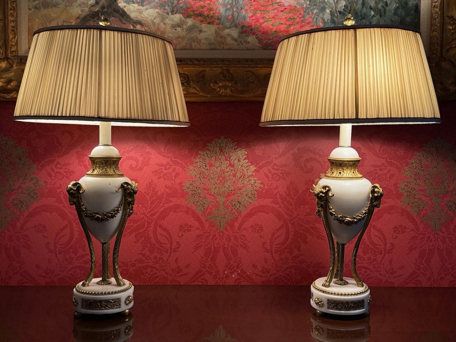 Pair of French Louis XVI-style Urn Lamps: A pair of French Louis XVI-style gilt bronze-mounted white marble urn-form lamps with ram's head mounts, on hoof feet. Provenance: From a Rittenhouse Square, Philadelphia apartment designed by interio