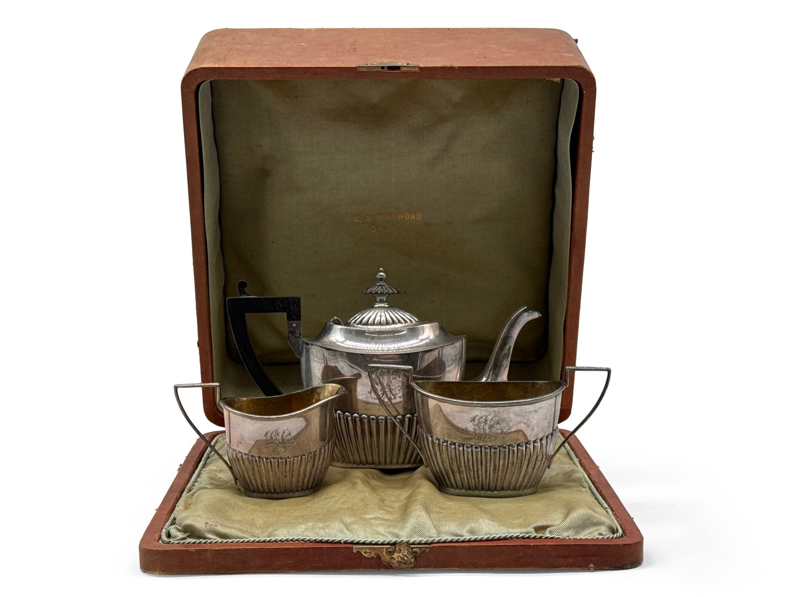Gorham Three-Piece Sterling Silver Tea Set: A Gorham three-piece sterling silver tea set to include a lobed lidded teapot with ebonized wood handle, double-handled sugar bowl, and creamer. Each hallmarked, and marked sterling. Includes original