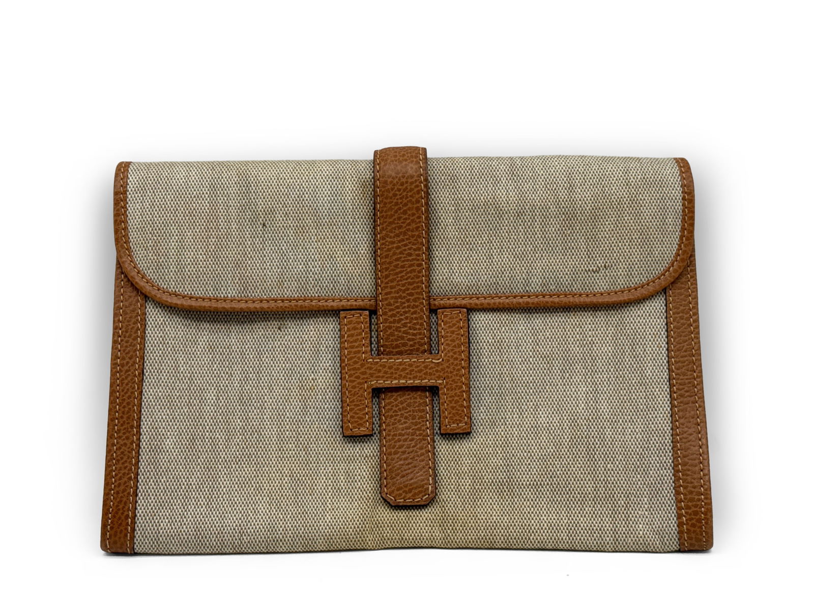 Hermès Jige PM Toile and Leather Clutch: An Hermès, Paris Jige PM clutch comprised of cognac colored leather and natural toile. Stamped Hermès on interior. 8in tall x 11in wide. | You have additional shipping options, and are not required