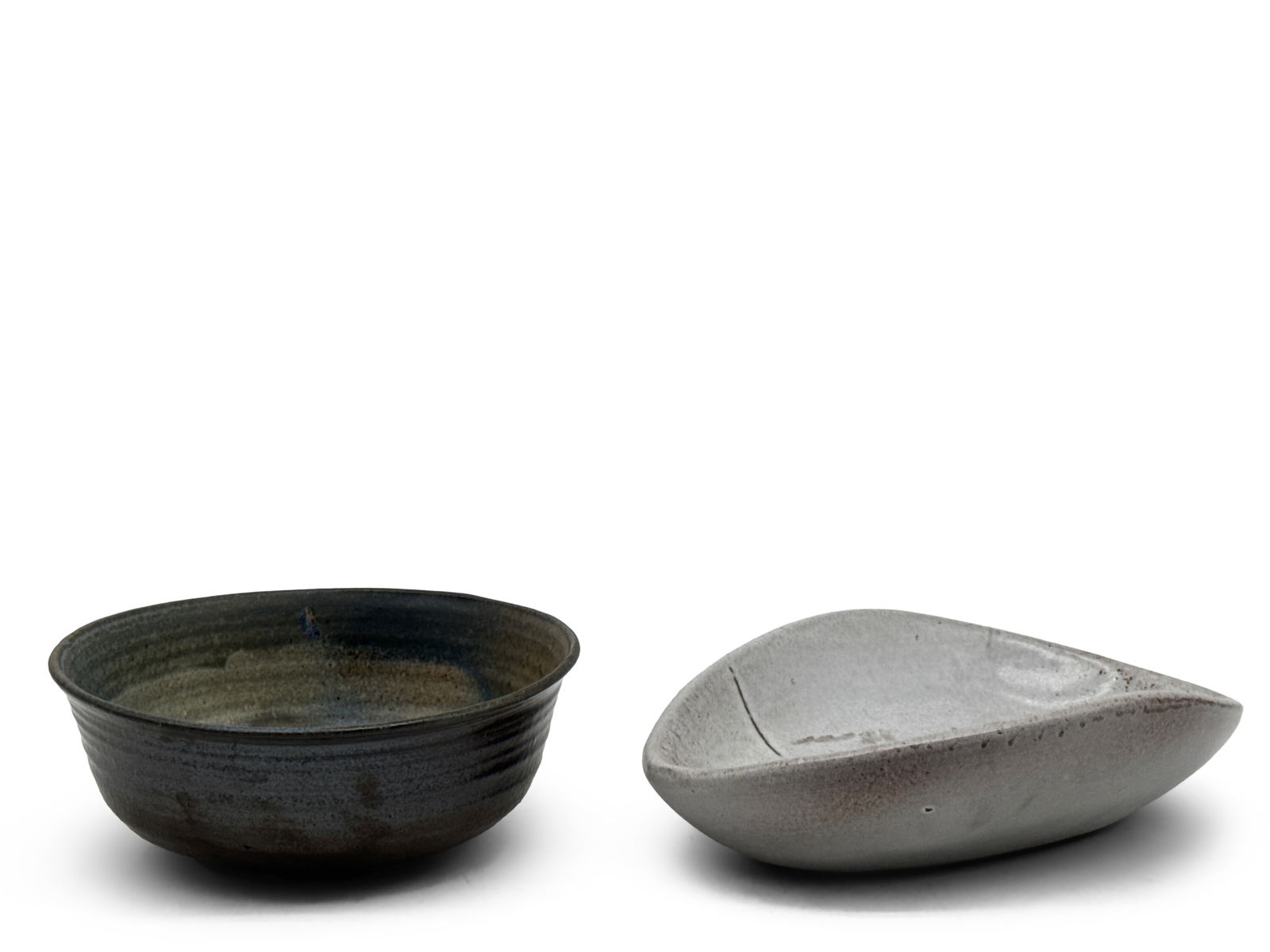 Two Pieces of Signed Studio Pottery: Two pieces of studio pottery to include an earthenware bowl with blue/green glaze signed "SMS", and an eggshell-glazed earthenware cache pot vessel of atomic form. Larger: 3in tall x 7in wide. | You