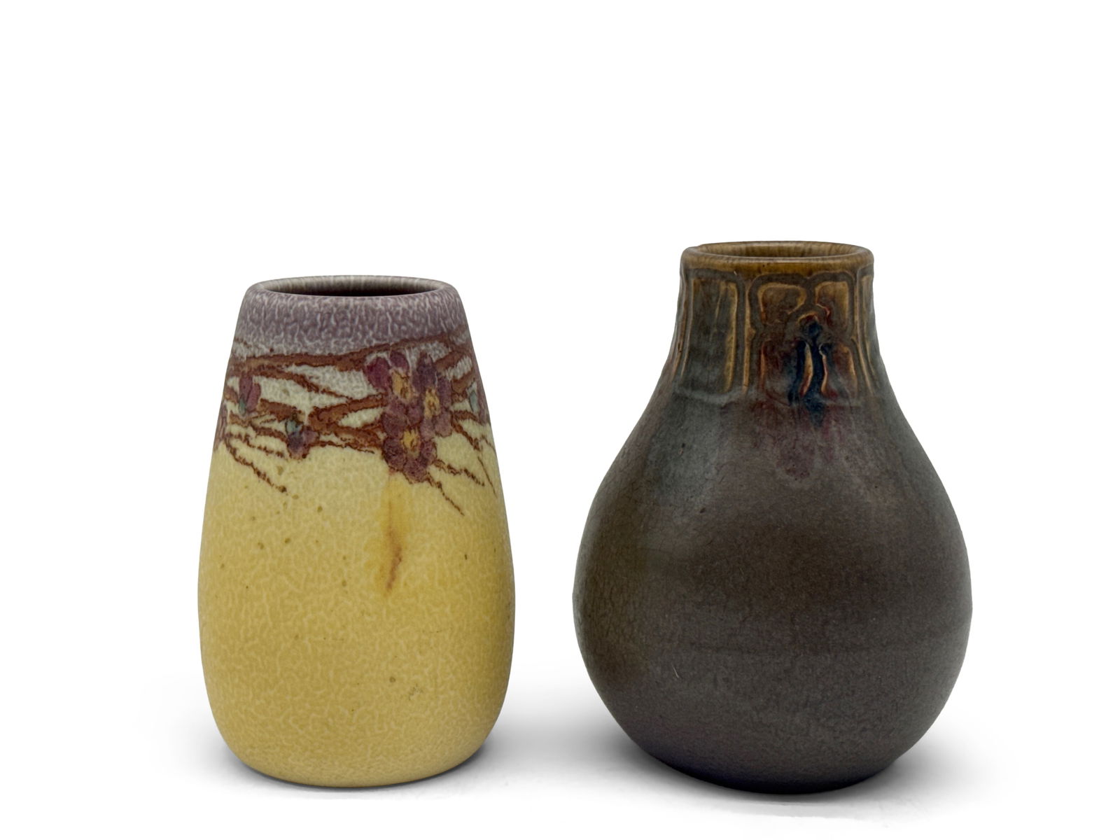 Two Rookwood Pottery Vases: Two Rookwood pottery vases to include a yellow-glazed vase signed "HM" and an Arts & Crafts-style vase with floral decoration. Each impressed with Rookwood mark. Larger: 5-1/2in tall x 3-1/2in wide. |