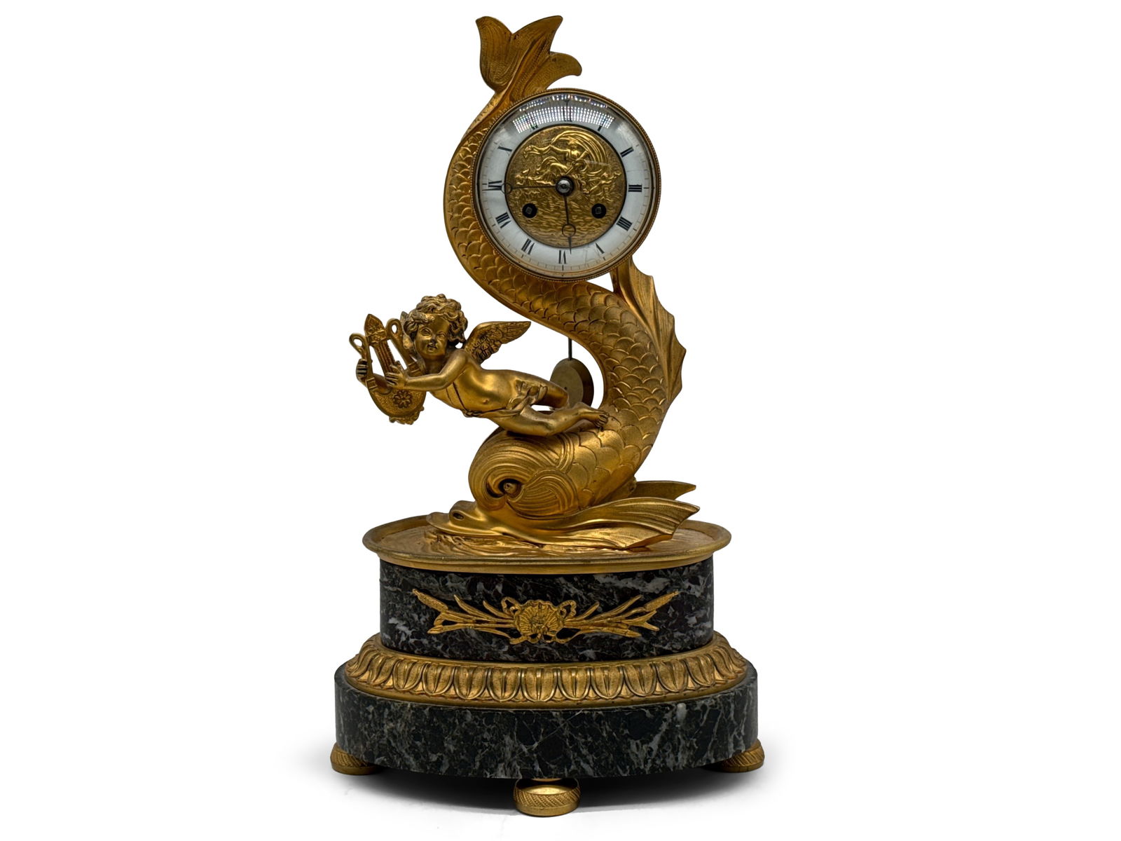 French Empire Gilt Bronze Mantle Clock: A French Empire gilt bronze mantel clock of classical form depicting cupid with his harp riding atop a dolphin, terminating on a green marble and gilt bronze base: 16in tall x 9in wide. | You have add