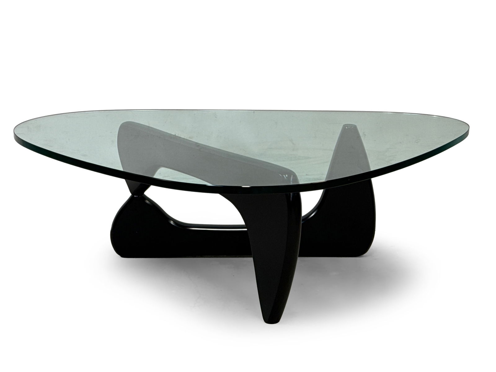 Isamu Noguchi for Herman Miller Coffee Table: An Isamu Noguchi for Herman Miller IN-50 coffee table, with a glass top over an ebonized lacquered base. Glass etched with signature and base with label. 15-3/4in tall x 50in wide x 36in deep. | You h