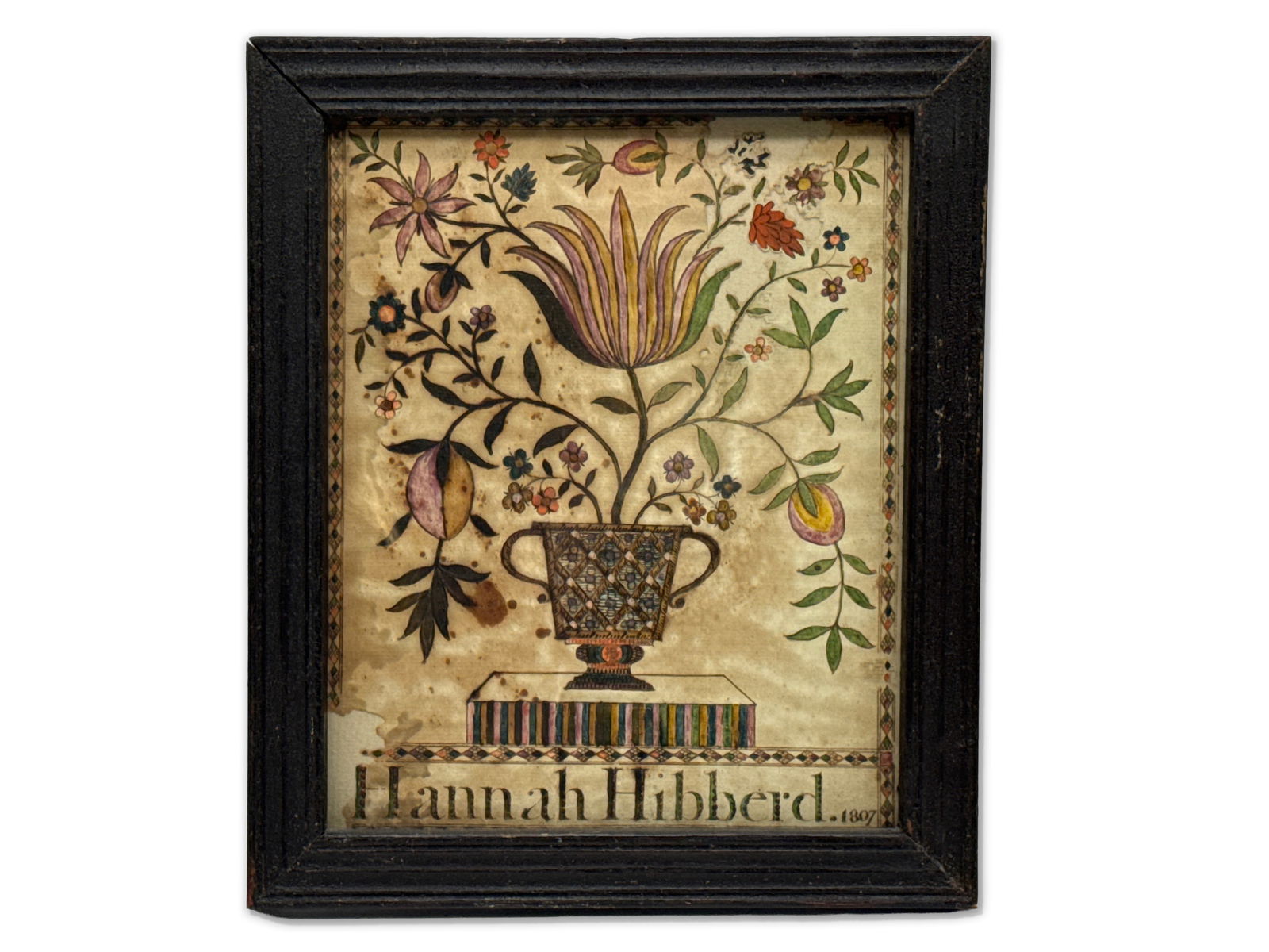 Hannah Hibberd 1807 Watercolor Fraktur: A 19th C. watercolor on paper fraktur depicting a scrolling flower urn. Marked Hannah Hibberd, dated 1807. Frame: 11-1/2in x 9-1/2in. Fraktur: 9-1/2in x 7-1/2in. | You have additional shipping