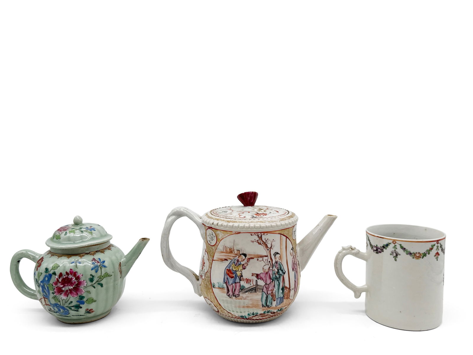 Chinese Export Teapots and Coffee Cup: A grouping of Chinese export items to include a celadon-glazed teapot with floral decoration, a famille rose teapot with genre scene, and a floral-decorated coffee mug. Largest teapot: 6in tall x 9in