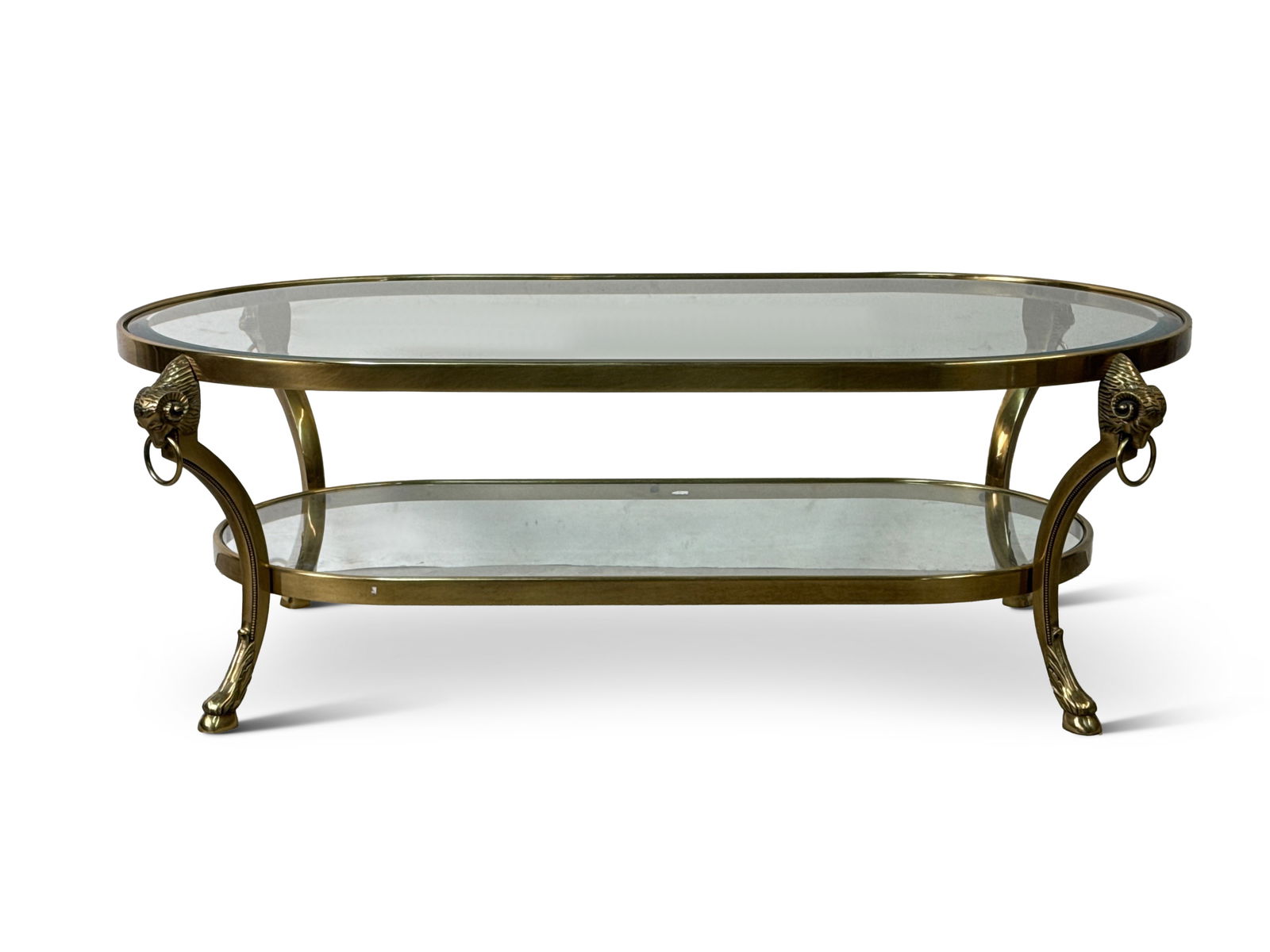 Neoclassical-style Brass Ram's Head Coffee Table: A Neoclassical Maison Jansen-style two-tiered coffee or cocktail table with ram's head and ring mounts. 16-1/2in tall x 48in wide x 26in deep. | You have additional shipping options, and are not requi
