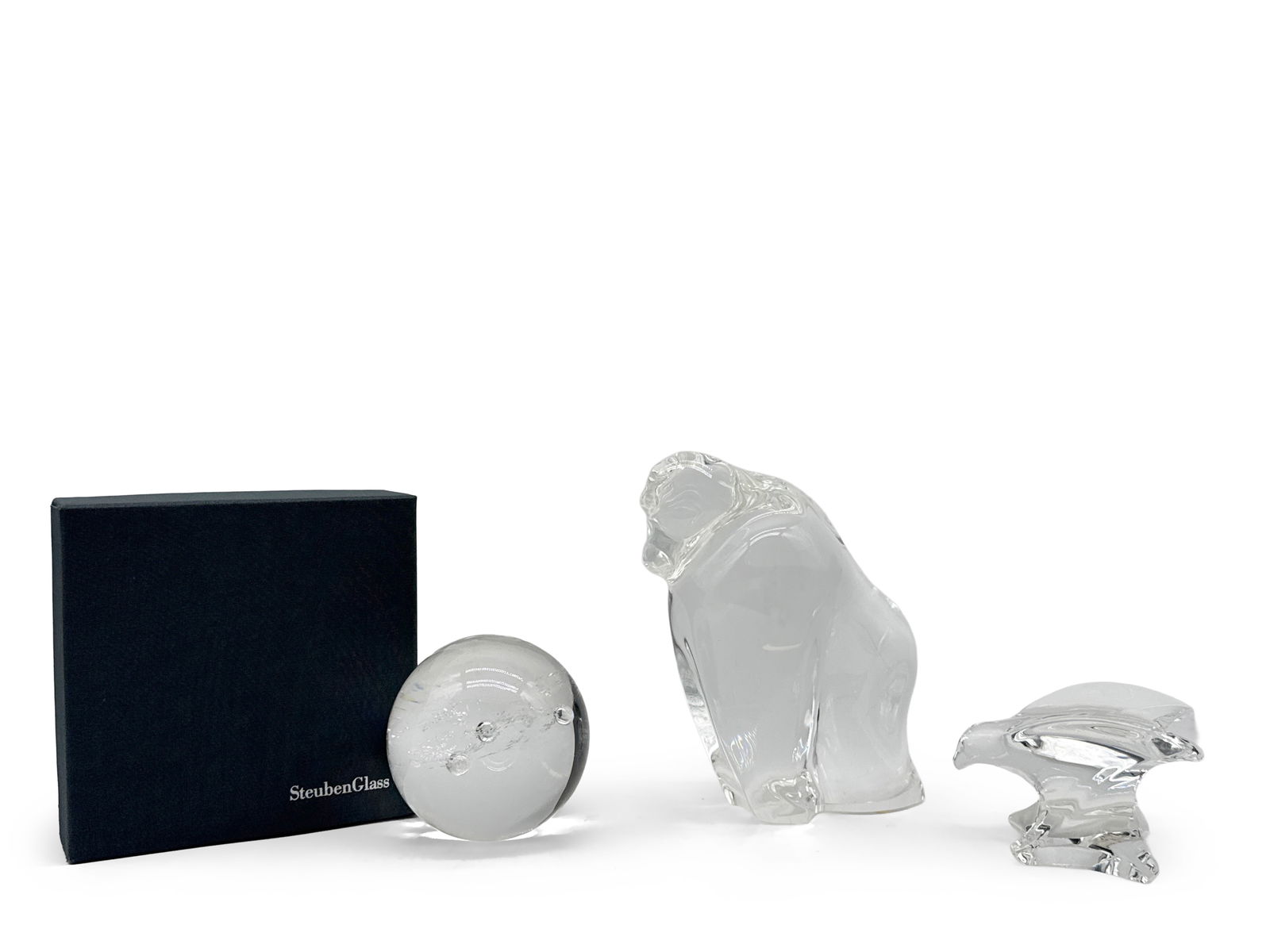 Steuben Glass Gorilla, Eagle, and Paperweight: A grouping of Steuben glass items to include a paperweight orb with Steuben box, a gorilla and an eagle. Each marked Steuben. Largest: 7-1/2in tall x 6in wide. | You have additional shipping options,