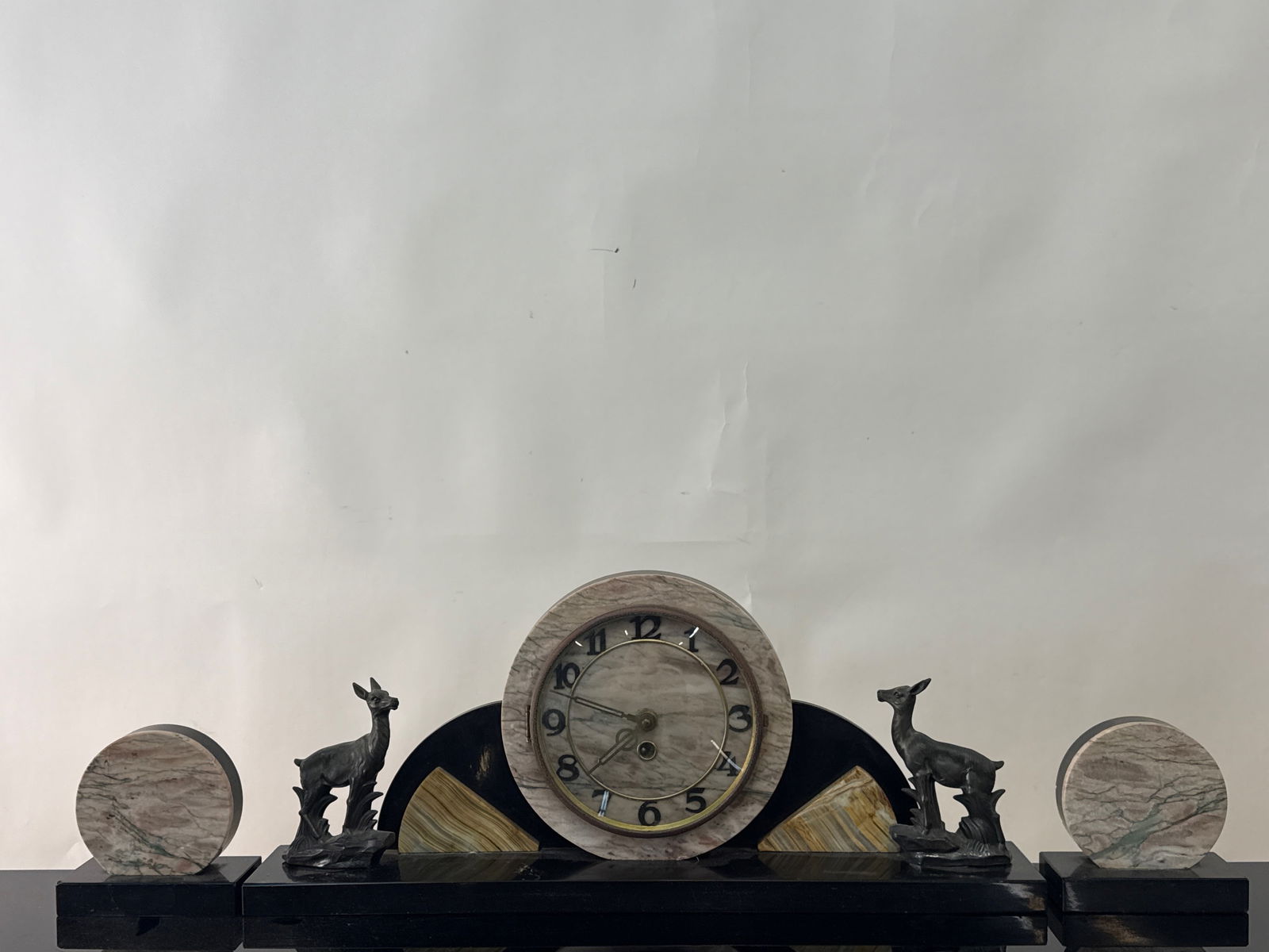 French Art Deco Mantel Clock and Bookends: Grouping to include a French Art Deco rouge marble mantel clock with two deer-form cast metal statues and two matching rouge marble circular bookends. Clock: 9in tall x 21in wide. | You have