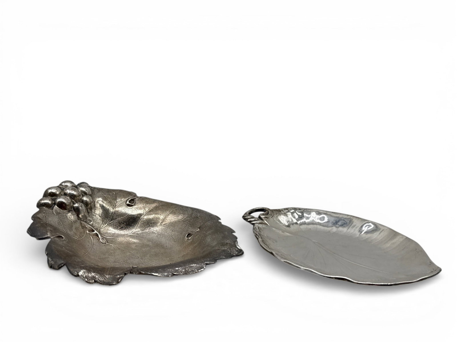 Two Art Nouveau Sterling Leaf-Form Dishes: Two Art Nouveau sterling silver leaf-form dishes to include a Meridian Brittanica dish with a curling stem marked 120; and a Watson grape leaf candy dish with a grape cluster handle, hallmarked and nu