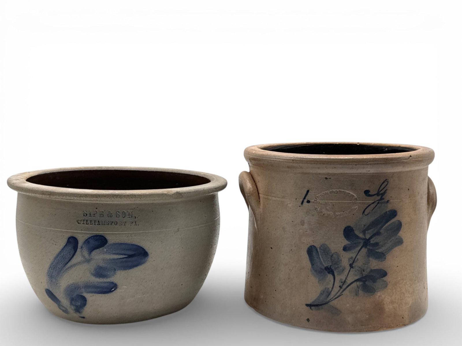 Union Pottery and Sipe & Son Stoneware Crocks: Two salt-glazed stoneware crocks to include a Union Pottery of Newark, NJ handled crock with cobalt blue floral decoration and stylized "G", and a Sipe & Son of Williamsport, PA crock with cobalt blue