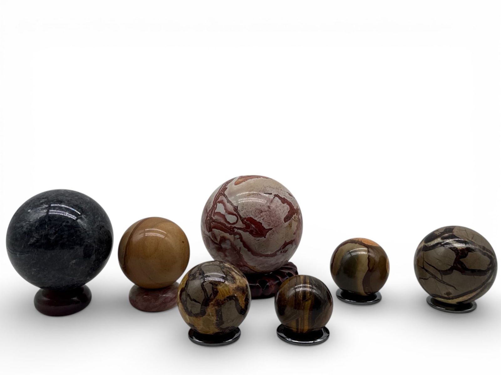 Seven Polished Mineral Spheres: A collection of seven polished mineral spheres to include rhodochrosite, larvikite, septaria, mookaite jasper, polychrome jasper, and tiger's eye. Largest: 4in diameter. | You have additional