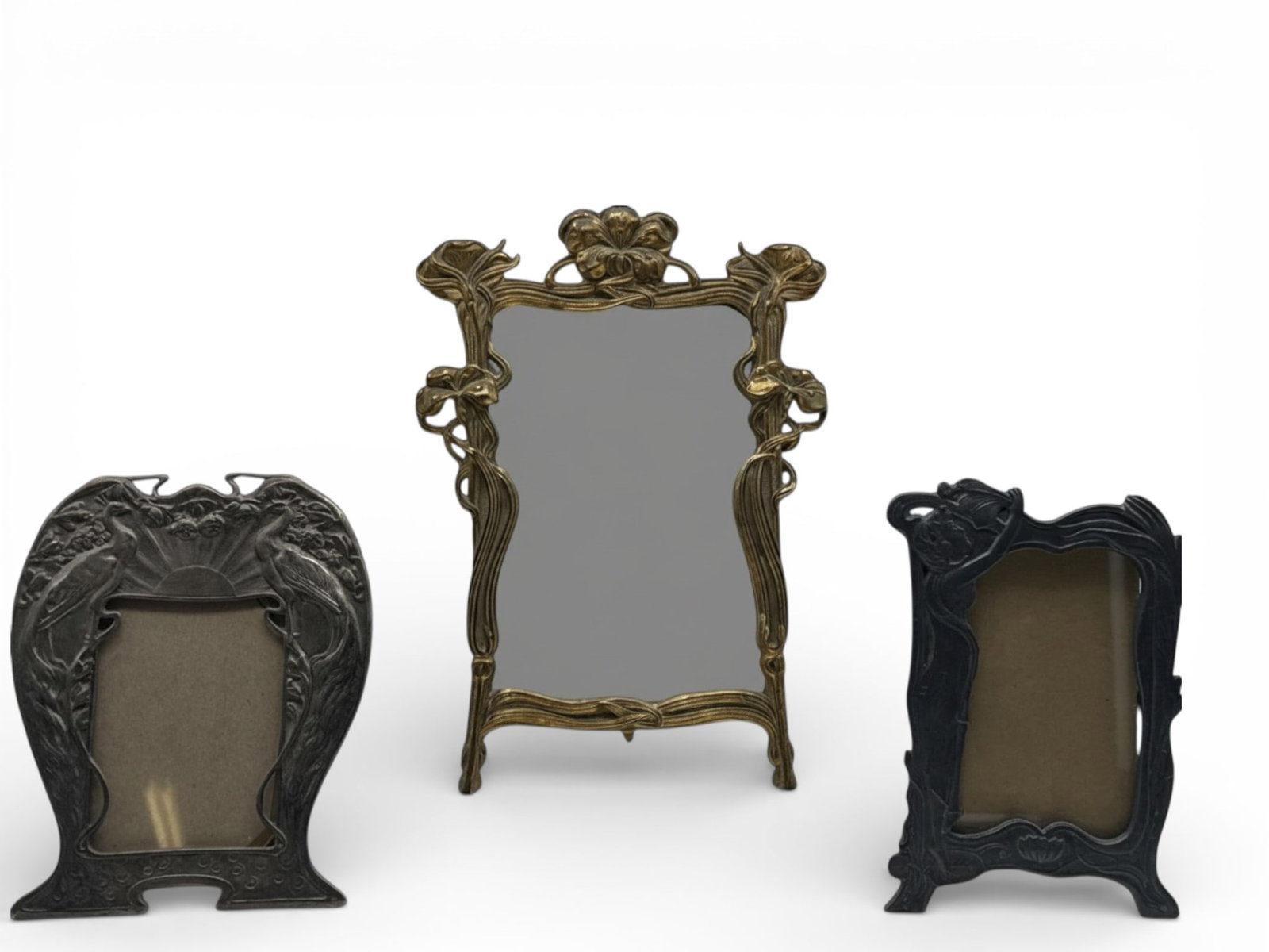 Art Nouveau Mirror and Pewter Frames: An Art Nouveau gilt-brass table-top mirror with floral decoration, and two pewter frames. Largest: 14in tall x 10in wide. | You have additional shipping options, and are not required to use Live Shipp
