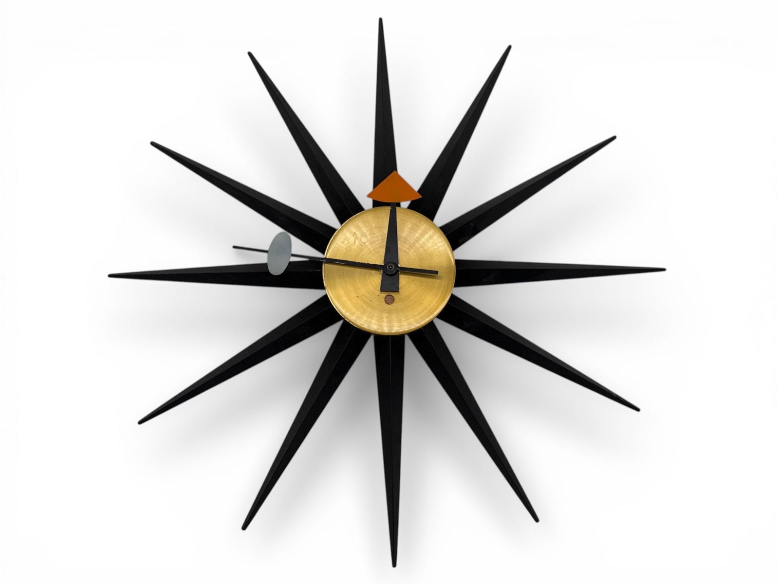 George Nelson Howard for Miller Sunburst Clock: A George Nelson for Howard Miller Sunburst clock with black wooden rays, brass center, and enameled hands. Marked Howard Miller Clock Co. Zeeland, Mich verso. 18in diameter. | You have additional ship