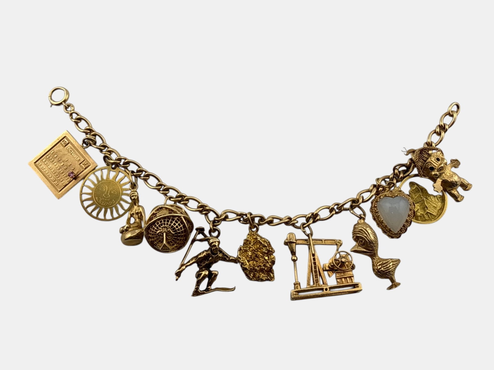 14K Yellow Gold 11-Charm Bracelet: A 14K yellow gold chain link bracelet with 11 charms; one marked 18K, the others marked or tested as 14K. 7-1/2in long. 42.1 dwt. | You have additional shipping options, and are not required to use Li