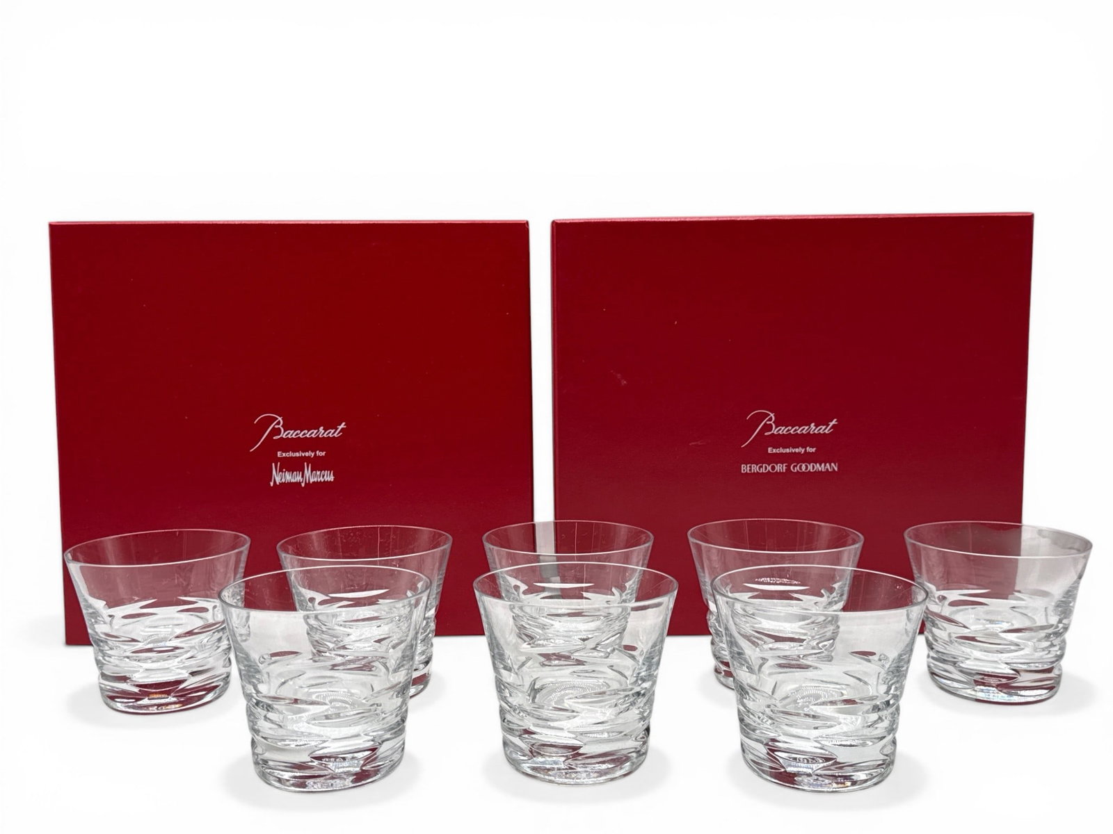 Eight Baccarat Crystal Lola Double Rocks Glasses: Two sets of four Baccarat Crystal "Lola" double old fashioned rocks glasses with impressed, textured bases. Each set includes original box. Each glass is marked Baccarat. Glass: 3in tall x 4in wide. |