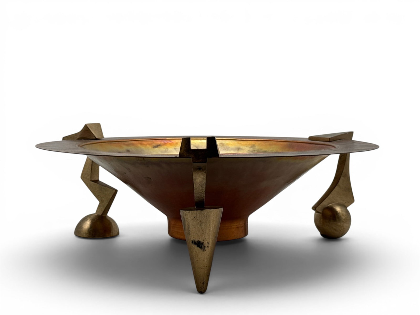 Thomas Roy Markusen Centerpiece Bowl: Thomas Roy Markusen (American, b.1940). A post-modern metalcraft centerpiece bowl in brass and copper, raised on geometric tripod feet. Signed. 6in tall x 8in wide. | You have additional shipping opti