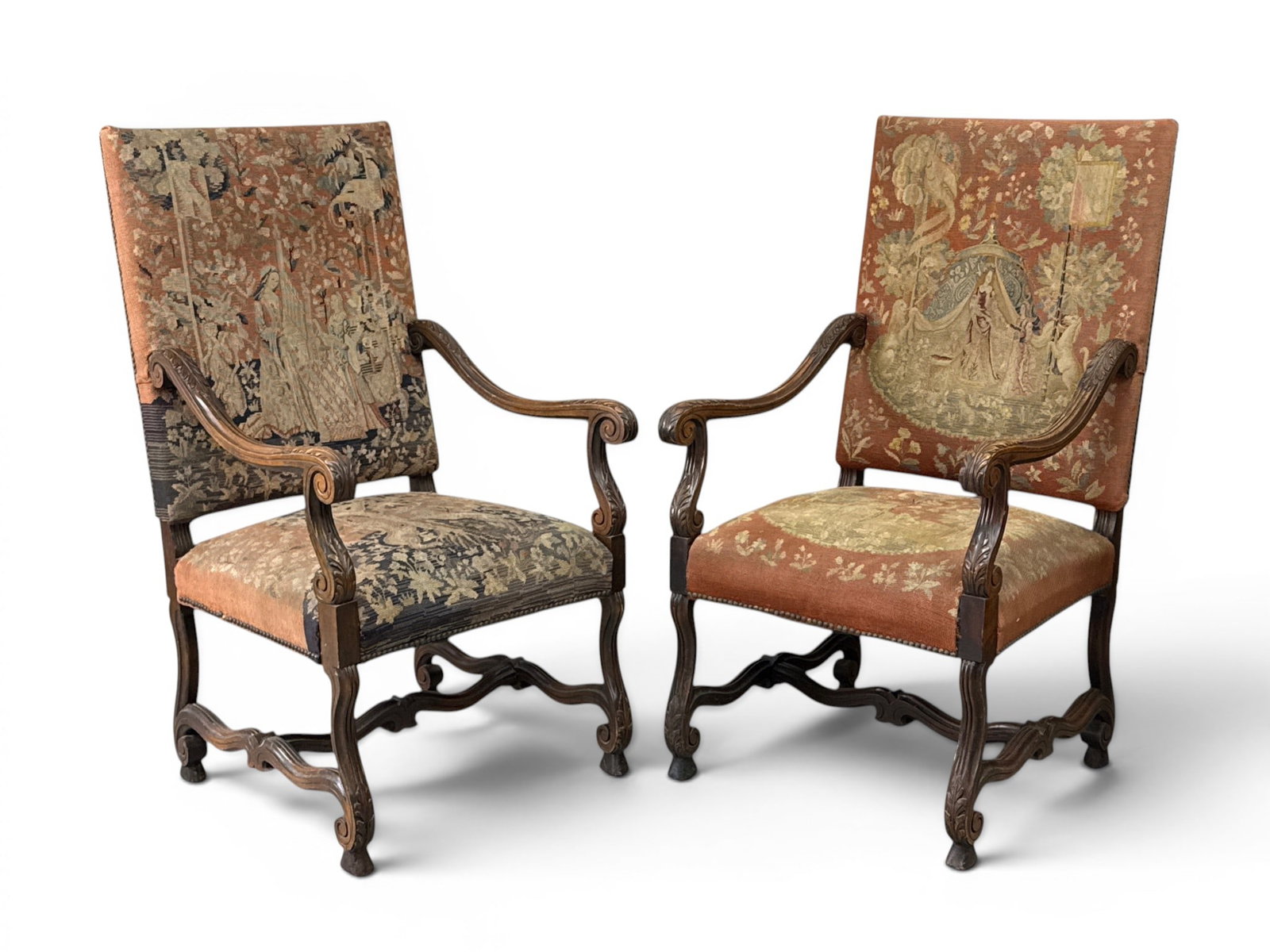 Pair of French Louis XIV-style Tapestry Armchairs: A pair of French Louis XIV-style fauteuils or armchairs with rolled arms, stretcher bases, and tapestry upholstery. Each: 47-1/4in tall x 26in wide x 26-1/2in deep. | You have additional shipping opti