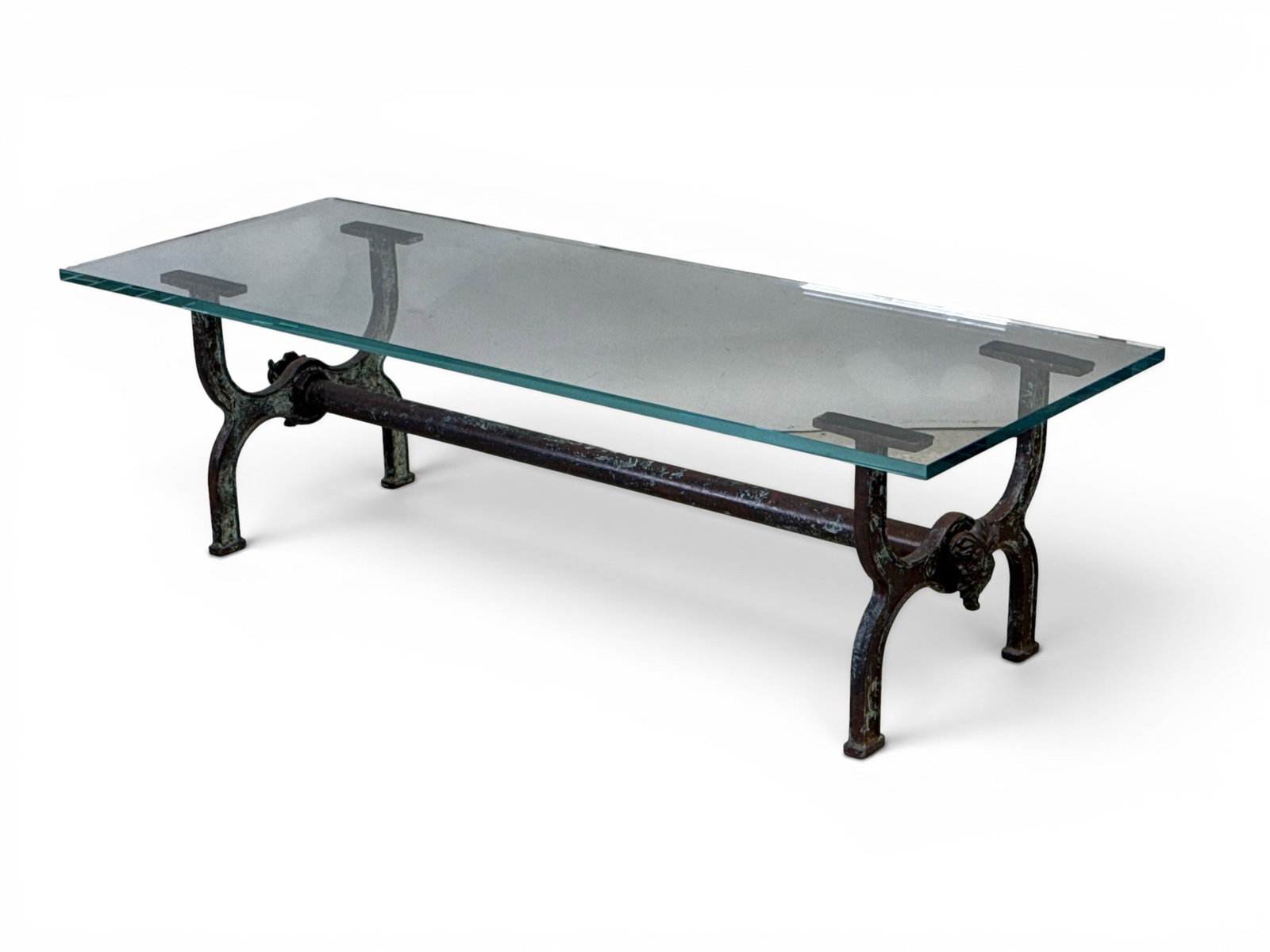 Decorator Patinated Iron Mask Coffee Table: A decorator glass top coffee or cocktail table with a patinated iron industrial base and mask mounts. 17in tall x 60in wide x 22in deep. | You have additional shipping options, and are not required to