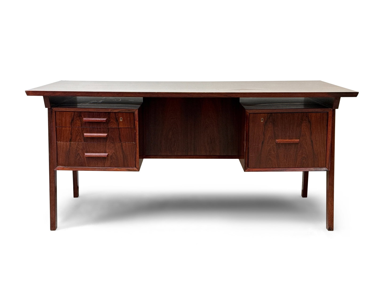 Midcentury Modern Rosewood Writing Desk: A midcentury modern rosewood desk with a rectangular floating top over a frame with drawers, on tapering legs. 28-1/4in tall x 63in wide x 32in deep. | You have additional shipping options, and are