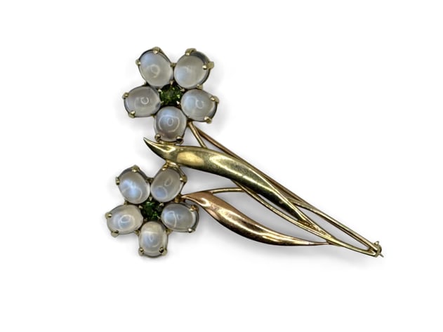 14K Moonstone and Peridot Floral Brooch: A marked 14K two-tone gold floral pin with two flowers made with moonstone cabochons and central faceted peridots. 2-1/2in x 1-5/8in. 6.94 dwt. | You have additional shipping options, and are not requ
