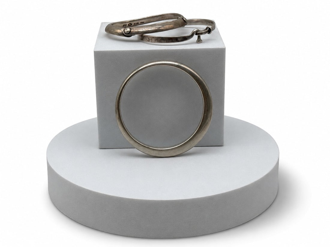 Three Georg Jensen Sterling Silver Modernist Bangles: Three Georg Jensen sterling silver modernist bangle bracelets to include two designed by Vivianna Torun, patterns 440 and 204, and a heavy Mobius bangle numbered 168. Largest: 3in wide. 4.05 ozt. | Yo