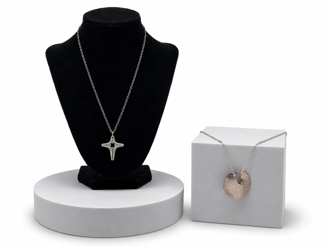 Two Georg Jensen Sterling Silver Modernist Necklaces: Two Georg Jensen sterling silver modernist necklaces to include a Vivianna Torun Bulow-Hube pattern 274 pendant, and a Henning Koppel Nordic cross pendant, pattern 179. Each on a sterling silver chain