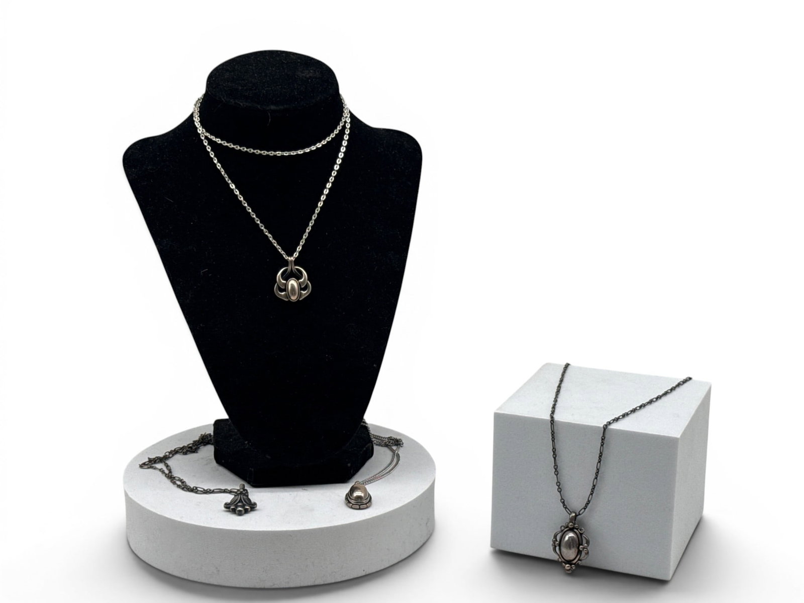 Four Georg Jensen Sterling Silver Necklaces: Four Georg Jensen sterling silver necklaces with stylized and modernist designs, each hallmarked and on a sterling silver chain. Pendants: 1in tall x 1in wide. 1.53 ozt. | You have additional shipping