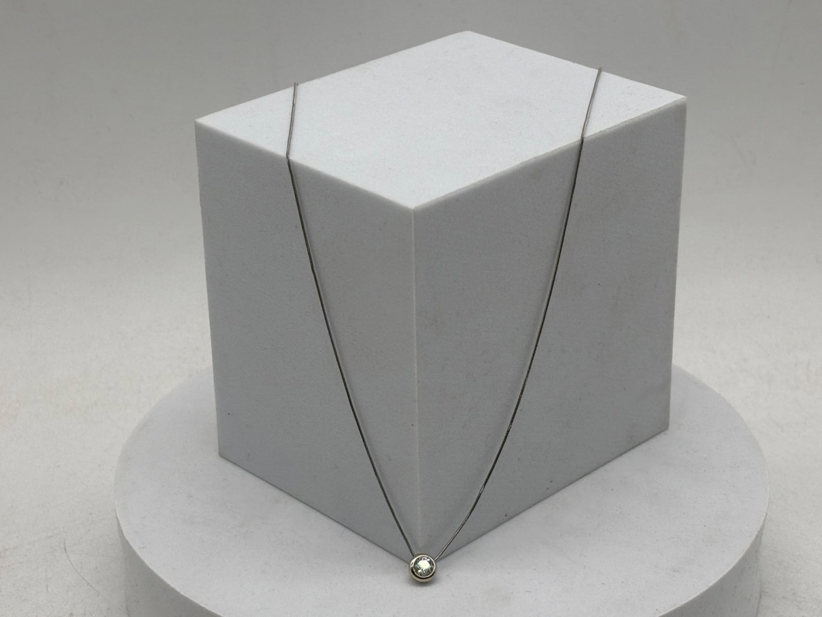 Clyde Duneier 14K Solitaire Diamond Necklace: A Clyde Duneier 14K white gold snake chain with bezel set solitaire diamond pendant. Marked CID and 14K. 20 in chain. 2.12 dwt. | You have additional shipping options, and are not required to use Live