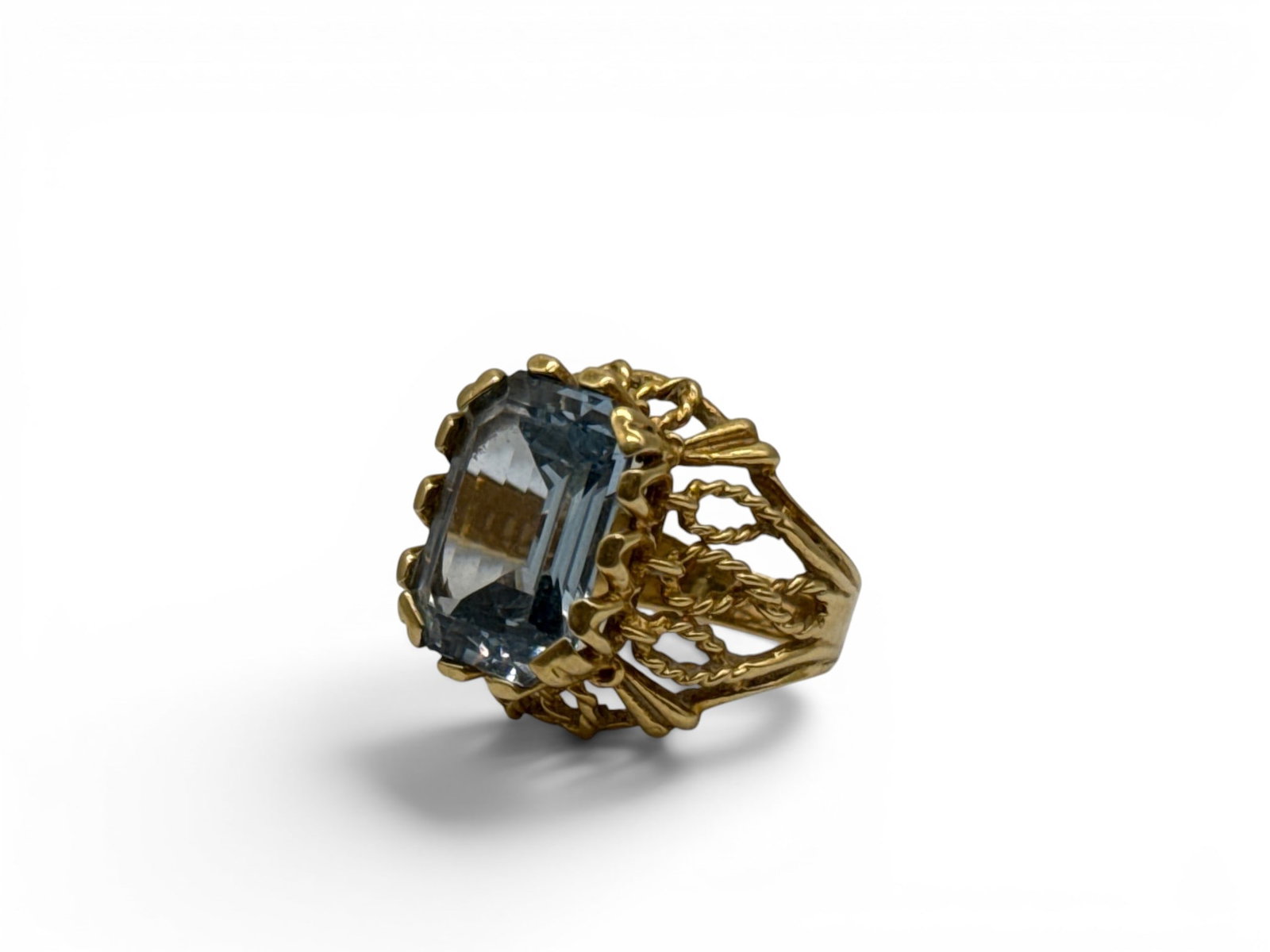 18K Emerald Cut Aquamarine Ring: An 18K yellow gold ring with filigree twist raised shoulders set with an emerald cut aquamarine stone. Ring tests as 18K. Size 6-1/4. 6.81 dwt. | You have additional shipping options, and are not requ
