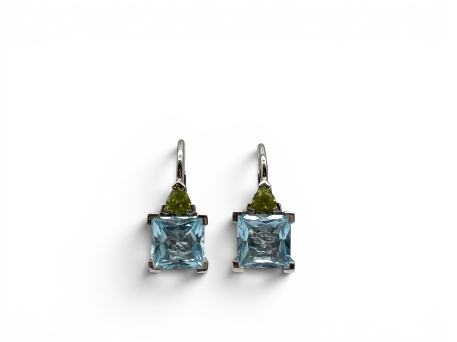 18K Palladium, Blue Topaz and Peridot Earrings: A pair of 18K palladium white gold drop earrings with square cut blue topaz and green peridot stones. Hallmarked and marked 18K. 3/4in tall. 3.60 dwt. | You have additional shipping options, and are