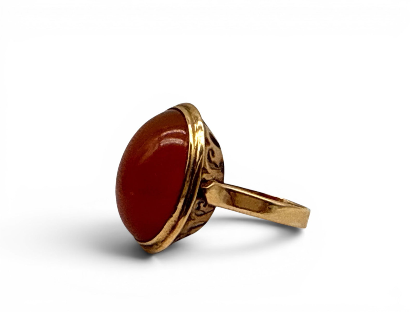 12K Domed Ring with Sard Quartz: A 12K yellow gold ring with a large oval-shaped sard quartz cabochon of 3.80ct in a step-up bezel setting with modernist, stylized shoulders. Includes Independent Gemological Services appraisal circa