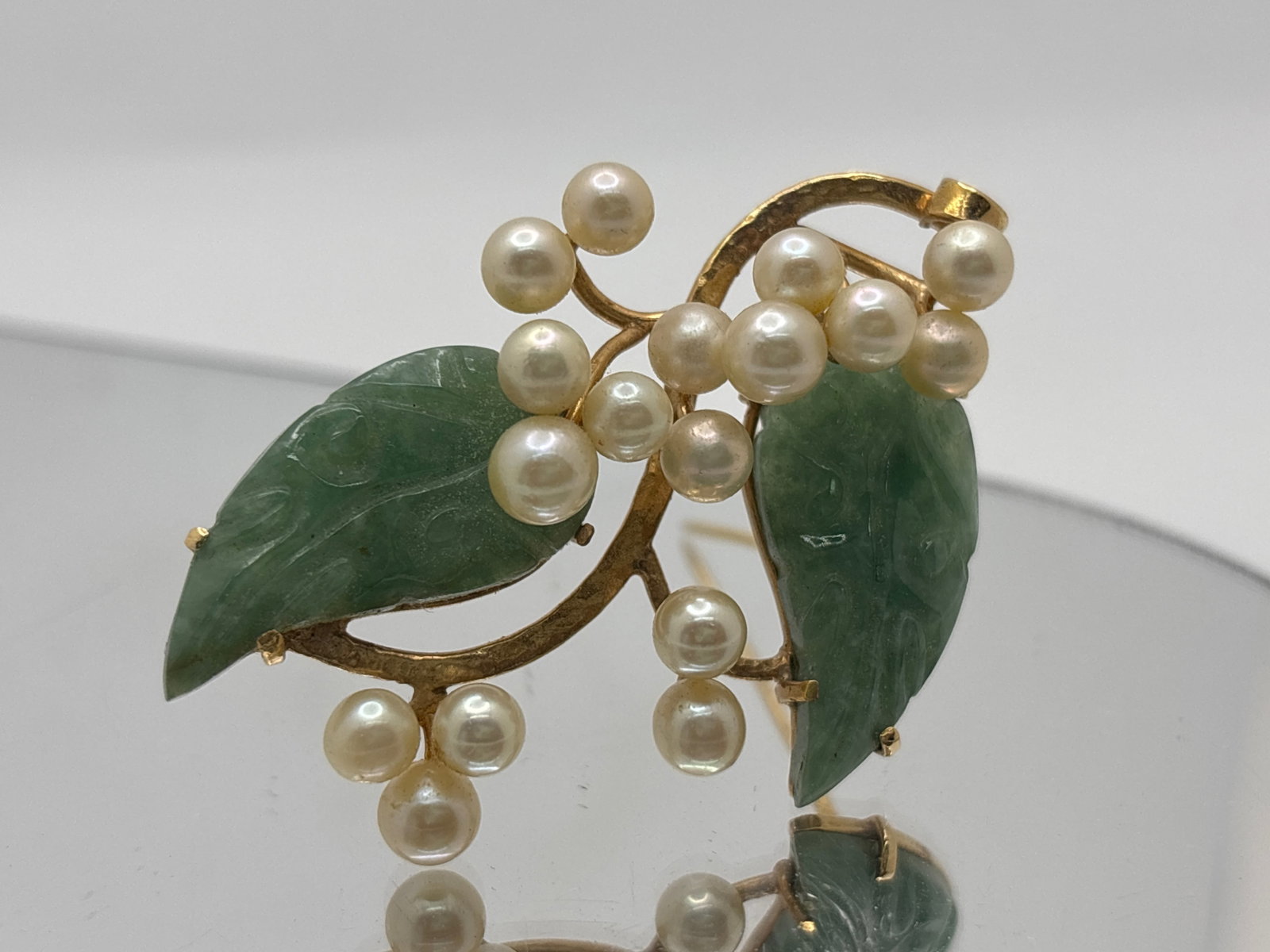 14K Yellow Gold Pearl and Hardstone Brooch: A pearl and leaf-carved hardstone brooch, signed Ming's and marked 14K on the back. Pearls: 5.2mm. 1-1/2in tall x 2-1/8in long. 9 dwt. | You have additional shipping options, and are not required to