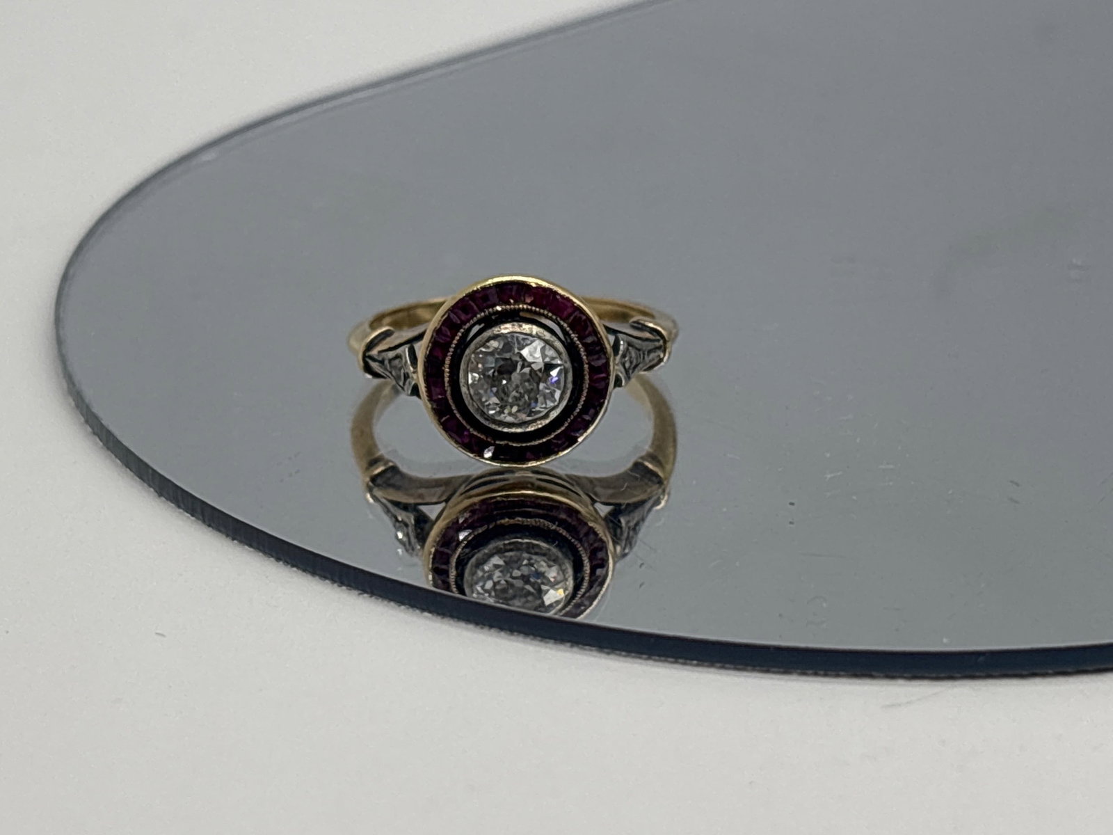 Art Deco Diamond and Ruby Target Ring: A 14K yellow gold ring with a 0.50 carat 5mm diamond in a calibre cut ruby halo, flanked by pav?-set diamond milgrained shoulders. Ring size 6. 2.19 dwt. | You have additional shipping options, and ar