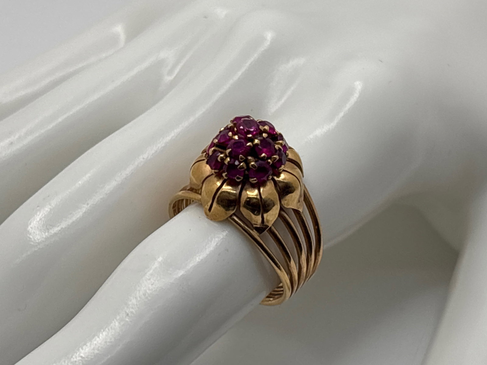 18K Yellow Gold and Ruby Domed Flower Ring: An 18K yellow gold multi-band flower-form ring set with a 3.2mm ruby, in a 3mm ruby surround. Egyptian hallmarks on shank. Ring size 8.25/8.5. 4.96 dwt. | You have additional shipping options, and