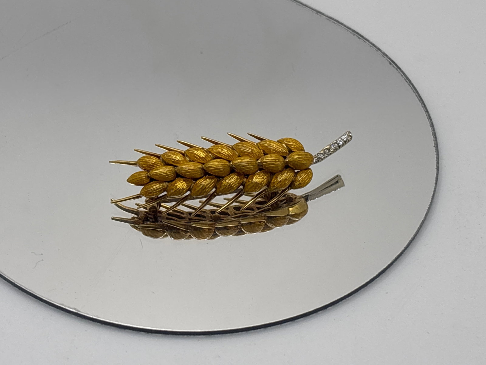 14K Enameled Wheat Sheaf Brooch: A 14K (tested) finely cast sheaf of wheat-form brooch with yellow guilloche and pav? diamond accents. Unsigned. 2in long. 6.54 dwt. | You have additional shipping options, and are not required to use