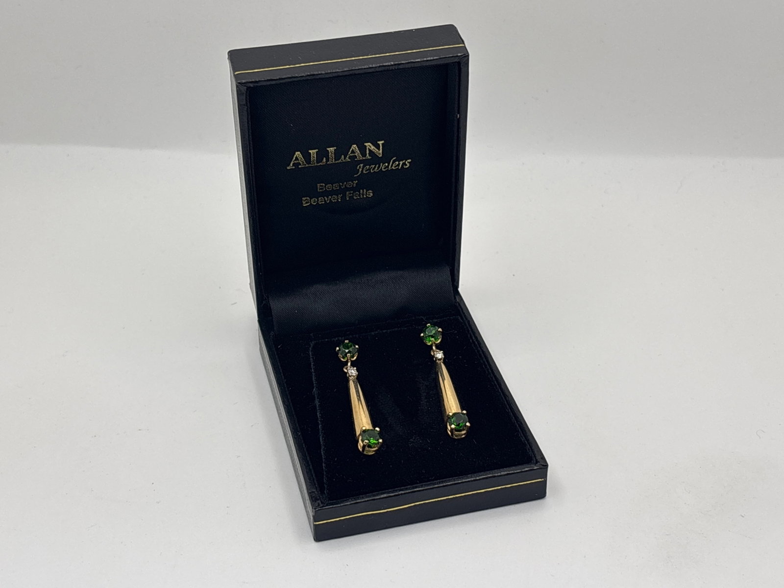 Pr. 14K Green Tourmaline and Diamond Drop Earrings: A pair of 14K yellow gold (tested) drop earrings each set with a 4.6mm round cut green tourmaline and a 2mm diamond joined drop with 4.5mm tourmaline at end. 1-1/2in long. 4.25 dwt. | You have